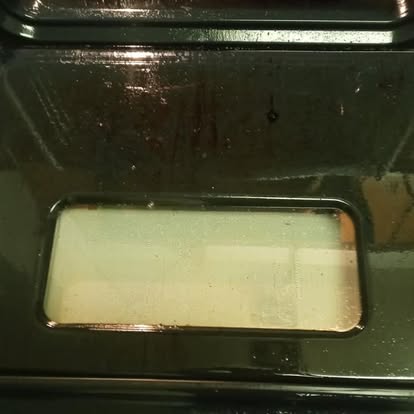Oven interior before deep cleaning with soiled baking tray