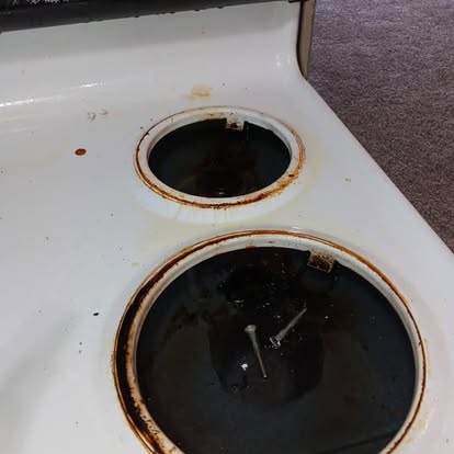 Stovetop burner drip pans before cleaning with heavy burnt residue